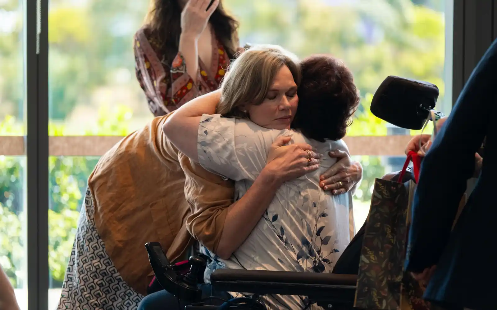 Two attendees share a warm hug.