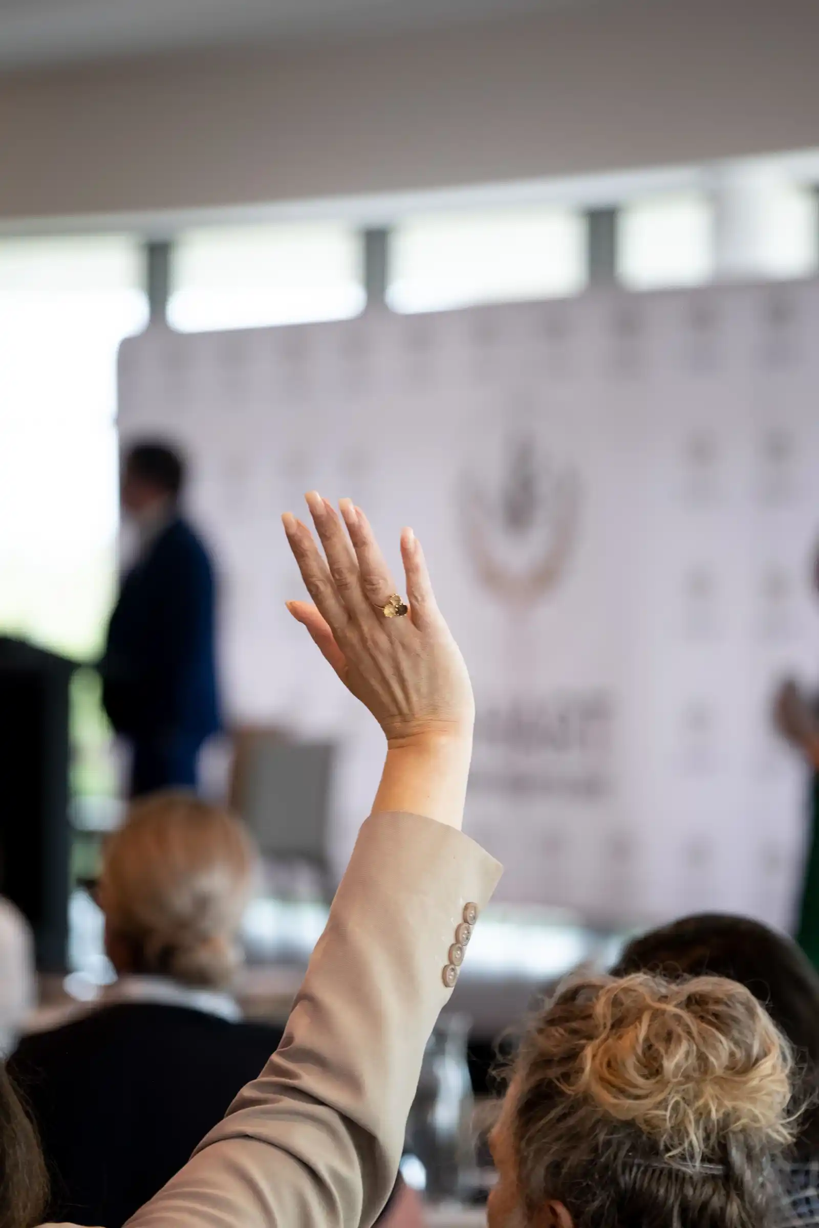 An audience member raises their hand to speak.